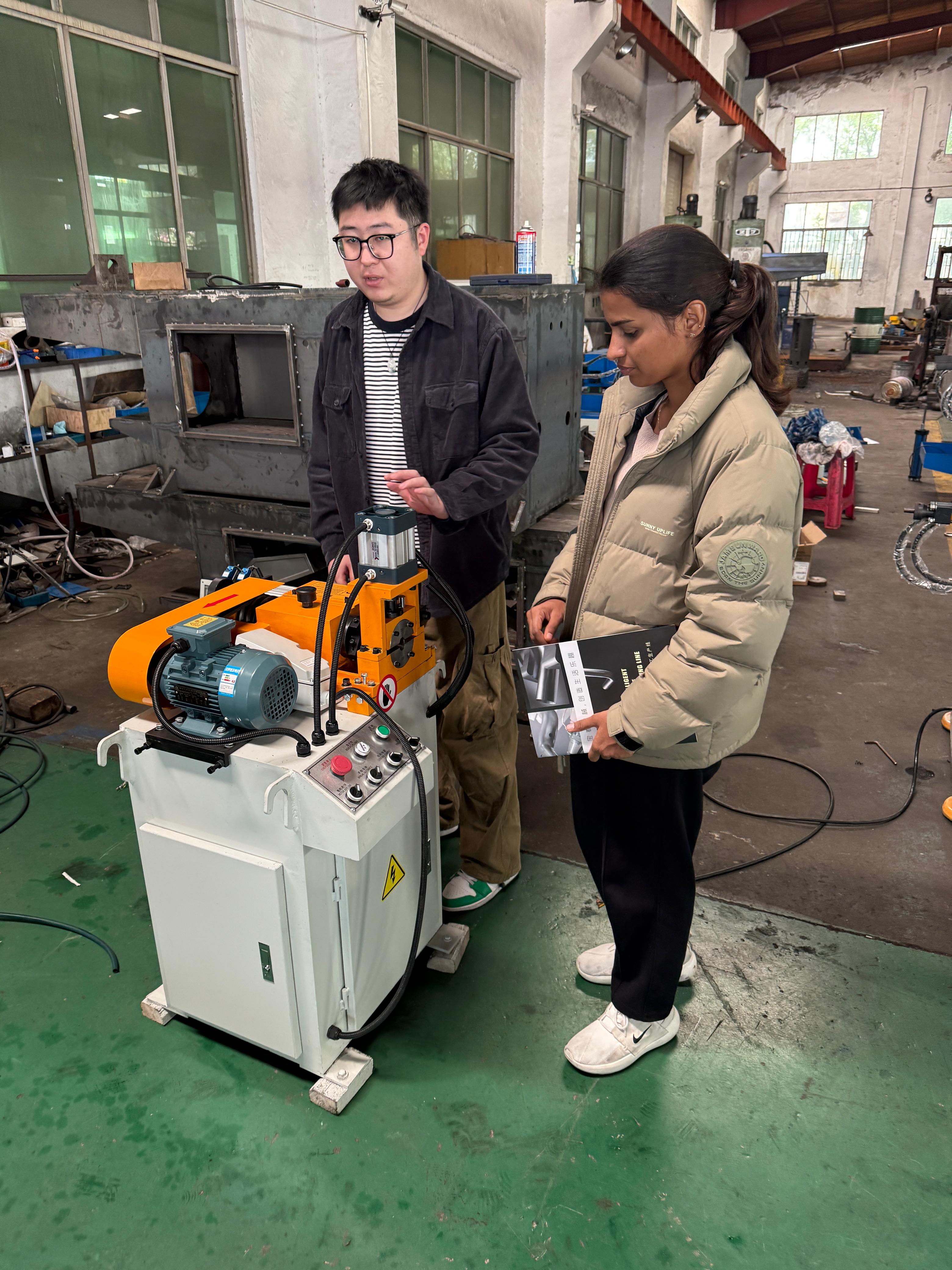 SourcersBiz reviewing machinery with a factory team in China